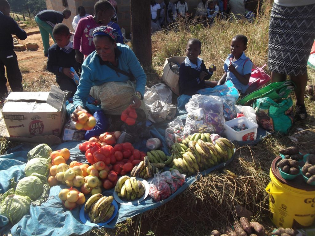 African lady selling her vegetables at a market.