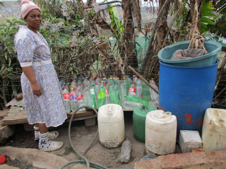 Nomusa Mkhize a member of Amandlethu group from Esiqoqweni zone collects water in empty Coke bottles.