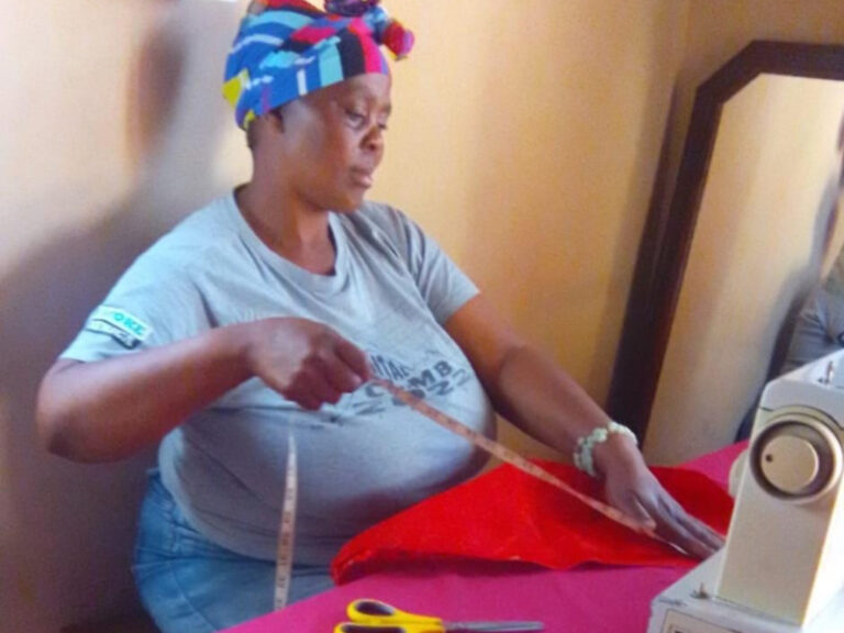 Busisiwe Ngcobo is a dedicated woman who focuses intently as she works at her sewing machine.