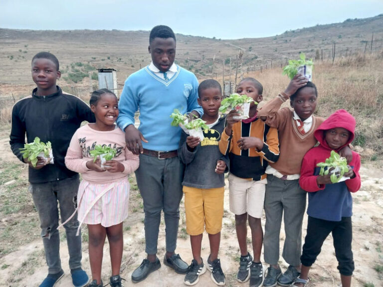 Children from Phumeceleni zone proudly carry seedlings they nurtured.